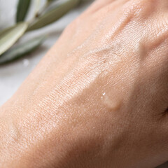 Fototapeta premium Close up of hydrated skin with moisturizing serum texture on hand