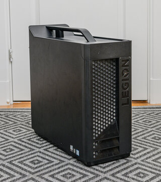 Gothenburg, Sweden - May 24 2026: Black Lenovo Legion desktop computer tower standing on patterned rug.