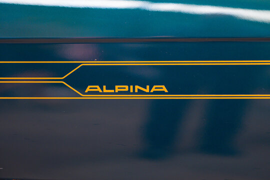 Gothenburg, Sweden - May 30 2026: Gold Alpina side stripe detail on glossy teal bodywork.