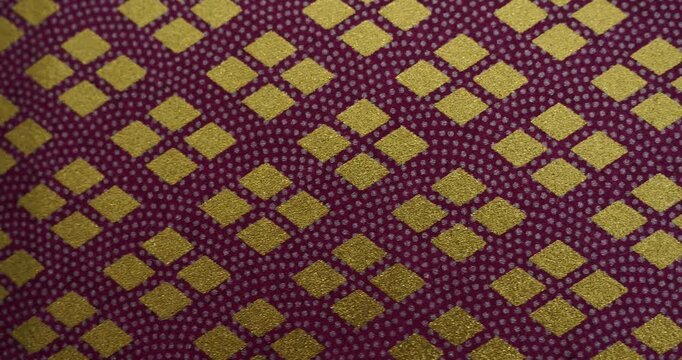 Traditional Japanese patterns of golden diamond shapes on purple backdrop - Geometric repeating texture featuring elegant metallic rhombus motifs on violet background