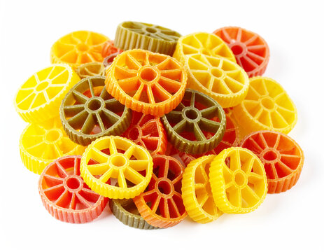 Pile of dry wagon wheel tri-colored pasta, white background. AI