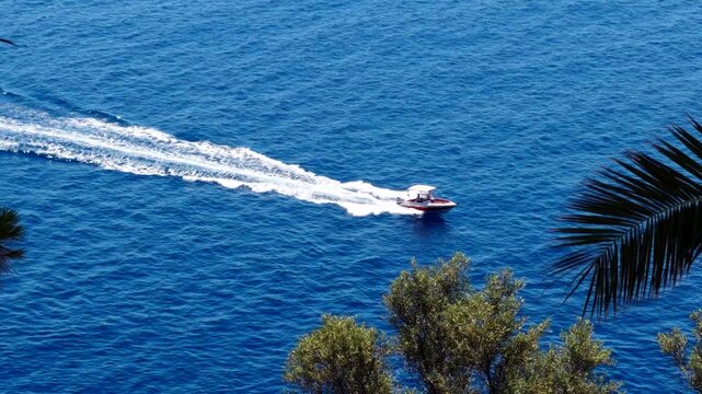 Speedboat Cruising On Deep Blue Sea Surface Leaving White Foam Water Trail. Summer Vacation. Marine Transportation 