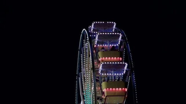 Ferris Wheel Illuminated With Colorful Neon Lights Rotating At Night. Amusement Park 
