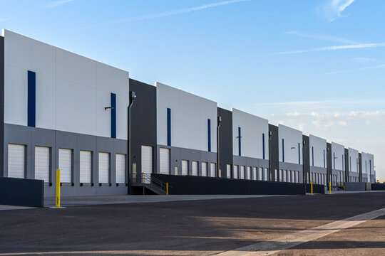 New modern industrial warehouse buildings with loading docks and distribution facilities, illustrating logistics infrastructure, supply chain operations, and commercial real estate development