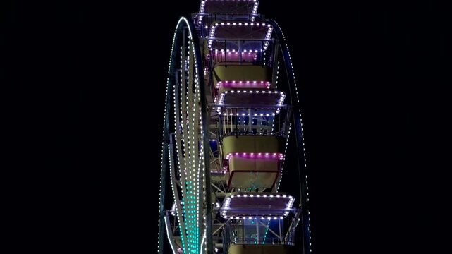 Illuminated Ferris Wheel Rotating At Night Amusement Park. Fair Ride Bright Neon Led 