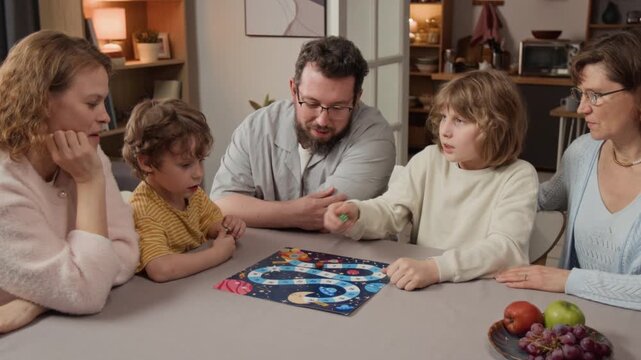 Caucasian multigenerational family playing board game together at table, rolling dice and moving pieces. Clip for marketing family bonding activities or domestic lifestyle products