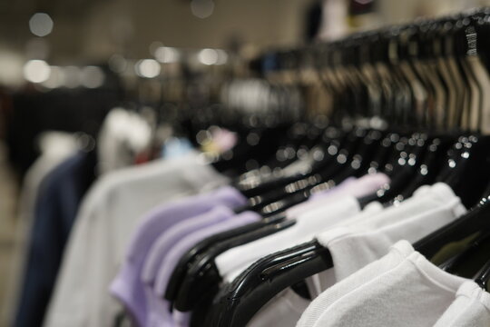 Blurred Clothing Rack With Casual Fashion Garments Hanging Inside Modern Boutique Store