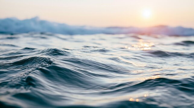 Gentle ocean waves with soft golden reflections from the setting sun, creating a peaceful and tranquil nature background
