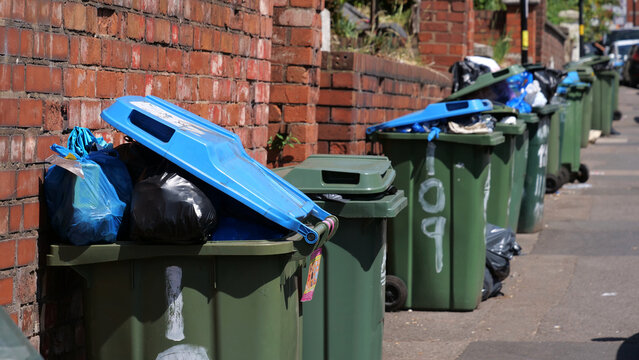 Wheelie bin, rubbish, overflow, waste, garbage, trash, row of overflowing wheelie bins on British street