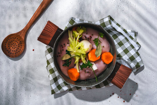 Homemade chicken soup raw ingredients. Fresh poultry meat, carrots, celery, and bay leaves for recipe.