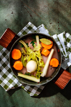 Raw chicken breast, carrots, and celery in a pot for homemade soup