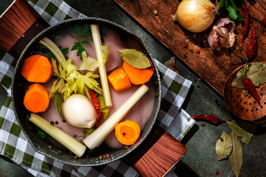 Top view of pot with raw chicken fillet and fresh vegetables for broth