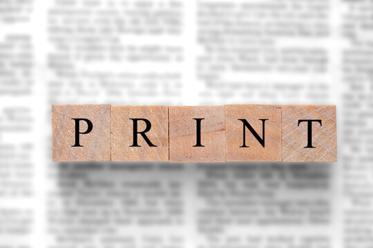 Newspaper background with wood blocks on top with the word print. Written press news media concept