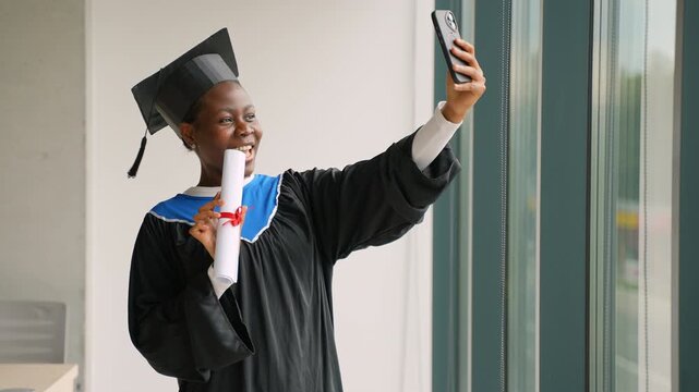 African american woman graduate taking a selfie with diploma
