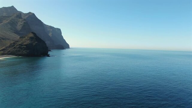 Aerial drone footage of the stunning coastline at La Aldea de San Nicolas, Gran Canaria. Majestic cliffs meet the calm, blue Atlantic Ocean