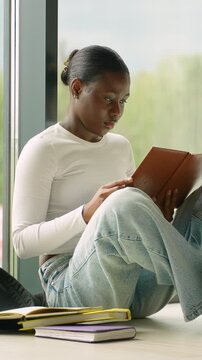 African american student reading a book in a university library