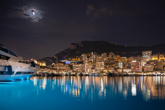 MONACO - JUNE 20, 2026: Night view of Port Hercule filled with luxury yachts and the illuminated Monte Carlo skyline in the background.