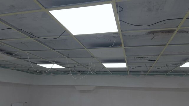 Ceiling panels and light fixtures are installed in a suspended frame