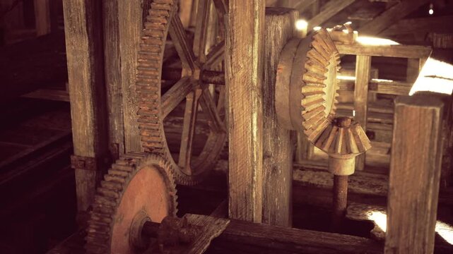 Museum exhibit mill machinery and gears displayed on wooden mounts with focused lighting, interpretive plaques and preserved industrial artifacts in curated