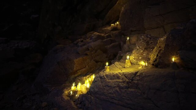Warm lantern cascade across crevice photographer capturing long exposure soft bokeh of flames tactile limestone layers cool blue highlights tranquil atmosphere
