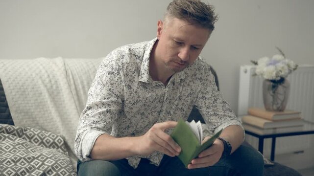 Young Man Flips Through Passport At Home and Checks Visa
