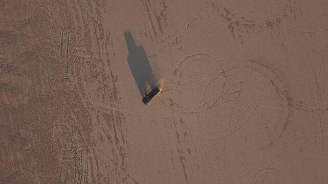 Drone shot of truck doing donuts in desert