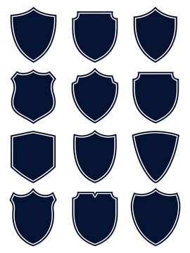 Collection of nine dark blue shield shaped emblems with white outlines on a transparent background for design and branding projects