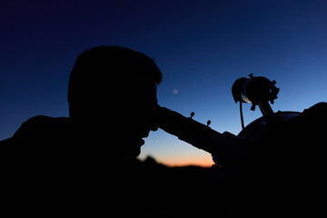 Amateur astronomer observing stars, planets, Moon and other celestial objects with a telescope in nature. © astrosystem