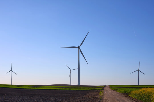 Wind turbines at sunset in green field &ndash; renewable energy, clean power, sustainable future.