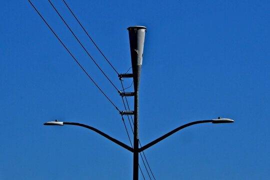 Consolidating street lights, electric lines and conical cellular antenna onto one pylon decrease city infrastructure costs 