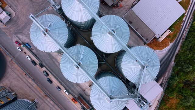 Flying circles above the tops of metal elevators. Grain storage in the large tanks.