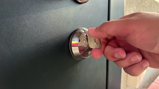 A man locks the door with a key
