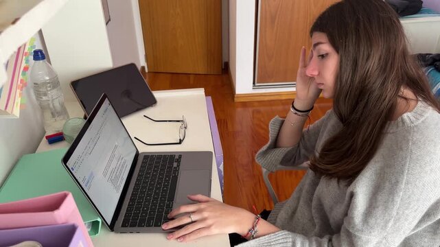 Frustrated student experiencing stress and headache while struggling with homework on her laptop, showcasing the challenges of e-learning and online education