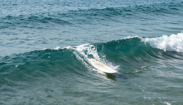 Surfboard floating on a sea wave with copy space