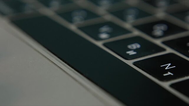 Close up of finger typing on laptop keyboard in modern digital workspace
