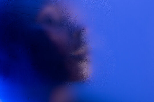 Black woman behind frosted glass with copyspace on background. 