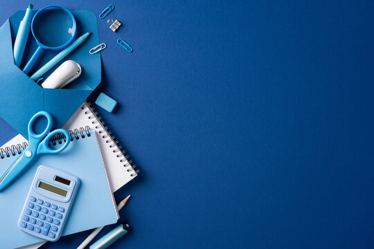 Back to school blue stationery flat lay with calculator scissors and notebook
