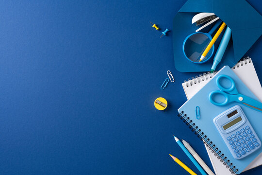 Back to school blue supplies flat lay with notebook calculator scissors and pencils
