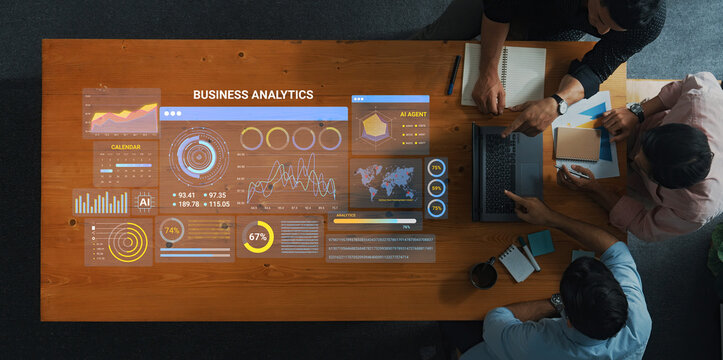 A group of professionals collaborates on business analytics in a modern office, utilizing data visualization tools to enhance decision-making processes and insights. Entropy.