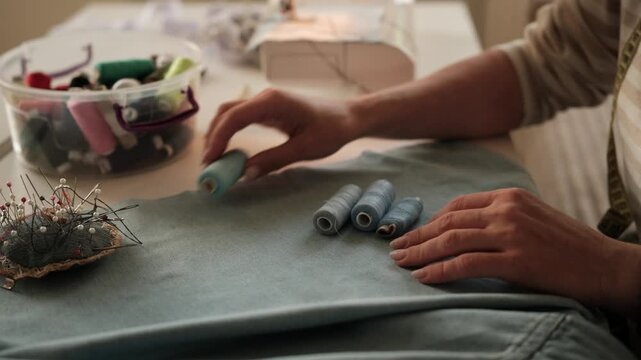 Seamstress Matches Thread To Fabric Color With Hands Up Close