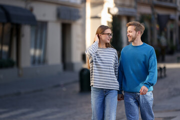 Fototapeta premium Couple holding hands together while walking outdoors, space for text