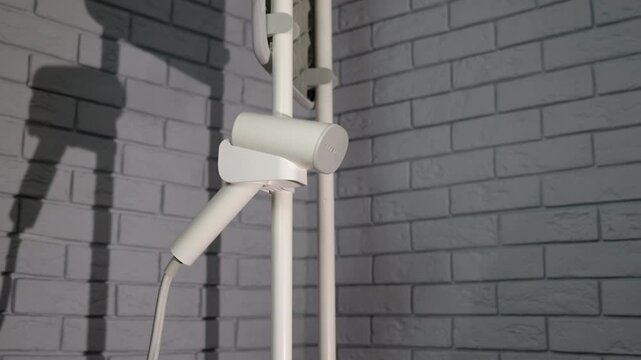 Steamer. Modern steamer for clothing care hangs on a stand