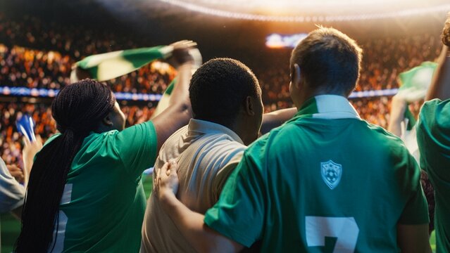 Football fans in the stadium stands react enthusiastically to a strong team performance, cheering as the players compete well and create a positive match-day experience for supporters.
