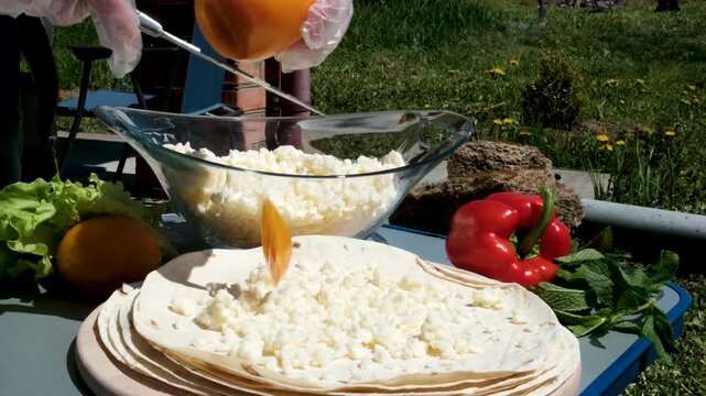 the process of cooking pita bread with cheese yellow tomatoes in sunlight cooking pita bread for lunch. High quality 4k footage