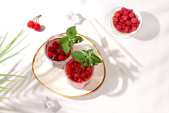 Detox water with raspberries, cherries, and currants, over ice. A refreshing summer homemade lemonade cocktail. Fruit juice and ingredients, weight loss concepts, healthy and natural food, mojito