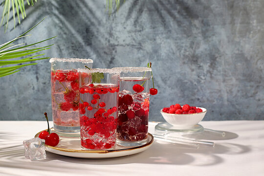 Detox water with raspberries, cherries, and currants, over ice. A refreshing summer homemade lemonade cocktail. Fruit juice and ingredients, weight loss concepts, healthy and natural food,