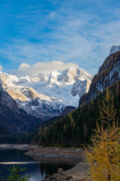 The colourful autumn scene of Austrian Alps with a view of the Dachstein mountain range covered by snow. Located in the Gosau Valley in Upper Austria. 