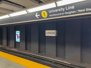 Obraz premium Empty Union station platform showing University Line sign and yellow tactile safety strip along track edge, Toronto July 2026