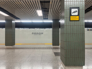 Obraz premium Empty Osgoode station platform featuring green tiled columns and security camera sign on wall, Toronto July 2026