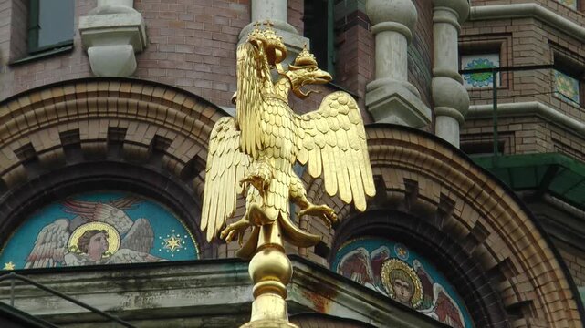 Saint Petersburg, Russia - August 4, 2026: A golden double-headed (three-headed) eagle on the building of the Church of the Resurrection of the Lord (Savior on Spilled Blood) on a cloudy summer day.
